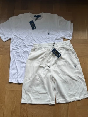 Ralph Lauren vitt set t-shirt & shorts – storlek M - Fräscht och sportigt set från Ralph Lauren i vitt. Setet innehåller en t-shirt och ett par matchande shorts. En perfekt och tidlös outfit för sommaren eller semestern. ✔ Storlek: M ✔ Märke: Ralph Lauren ✔ Färg: Vit ✔ Stilren design med den klassiska loggan 📩 Skicka ett meddelande vid frågor eller prisförslag! 🛍 Lägg till i ett paket för att spara upp till 20% rabatt! 📦 Garanterad leverans samma eller nästa dag 🌟 
