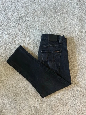 Svarta Nudie Jeans Lean Dean Storlek W34 - Mycket fina Nudie jeans i svart färg | Jeansen är i mycket bra skick och sparsamt använda. |  Äkta som allt annat jag säljer! ✅ |  Storlek: W34 | Skick: Mycket Bra Skick  - lite slitningar på grenen av byxan (SE SISTA BILDER)| Färg: Svart | Märke: Nudie Modell: Jeans |   Hör gärna av dig vid frågor så svarar jag så fort jag kan! 😁 |  (SKU - 185)