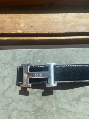 Svart bälte - En svart bälte med en silver spänne