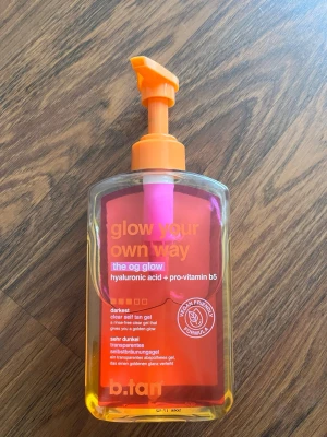 b.tan glow your own way brun utan sol - Självbruningsgel från b.tan med hyaluronsyra och provitamin B5. Produkten kommer i en genomskinlig plastflaska med orange pump och etikett. Gelen är klar och ger en djup solbrun färg. Vegansk formula och enkel att applicera.