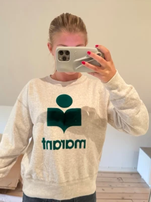 sweatshirt från Isabel Marant - Säljer en beige sweatshirt från Marant med grönt sammetstryck på bröstet i storlek 36. Jag är 163 cm lång