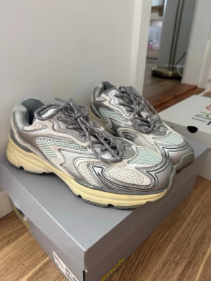 Grå och vita sneakers  - Som ny, men eftersom den bara har legat i garderoben har undersidan blivit lite gulnad.