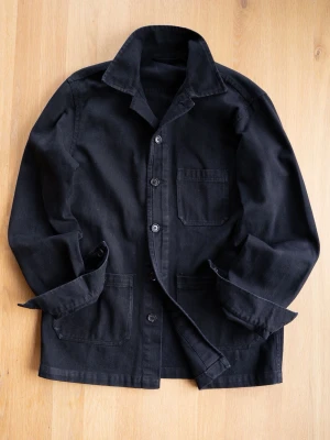 Svart Chore Jacket, size S - Stilren svart overshirt med tre framfickor och knäppning framtill. Tillverkad i kraftig bomull som ger en avslappnad men ändå snygg look. Perfekt att bära öppen över en t-shirt eller stängd som jacka. Klassisk krage och raka ärmar.