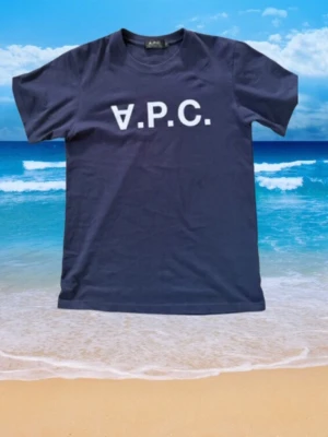 Mörk blå t-shirt från A.P.C. - Snygg mörk blå t-shirt från A.P.C. Storlek xs-s med klassisk vit logga framtill. Enkel och stilren design med normal passform och korta ärmar. Perfekt till jeans eller shorts för en clean look.