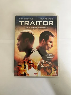 Traitor DVD-film - DVD-film med titeln 'Traitor' med Don Cheadle och Guy Pearce. Omslaget har en orange och svart färgskala med actionmotiv och text på både svenska och engelska. Plastfodral med tryckt omslag. Speltid 110 min.