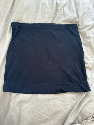 Svart kortkjol från H&M - Enkel och stilren svart kortkjol från H&M i mjukt bomullsmaterial. Kjolen har en rak passform.