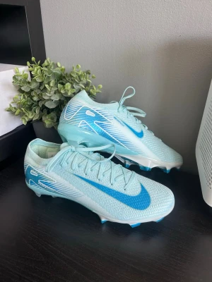 Nike Mercurial Vapor Elite 15 FG - Säljer dessa Nike Mercurial Vapor Elite 15 FG skorna i blå färg och storlek 42. Dem är använda ett halvt träningspass på konstgräs och går därav inte att lämna tillbaka pga att dem är grässkor. Samtidigt innebär det att skicket är som nytt. Har tappat bort lådan man fick med men kan skicka med en annan om det skulle önskas. Skriv vid fler frågor eller bilder.