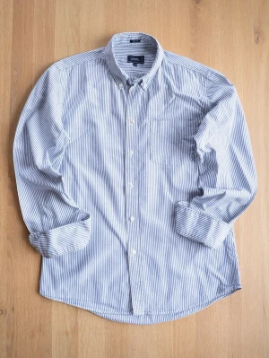Randig Oxford skjorta från Boomerang - Klassisk skjorta från Boomerang i blått och vitt med smala ränder. Skjortan har lång ärm, bröstficka och knappar framtill samt button down-krage. Tillverkad i mjuk bomull som känns skön mot huden. Perfekt för en clean och stilren look.