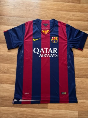 Barcelona matchtröja Messi #10 Nike - Säljer en FC Barcelona matchtröja från Nike med Messi #10 på ryggen. Tröjan har klassiska blå och röda vertikala ränder, klubbmärke på bröstet och Qatar Airways som sponsor. Materialet är lätt och andas, perfekt för fotboll eller träning.