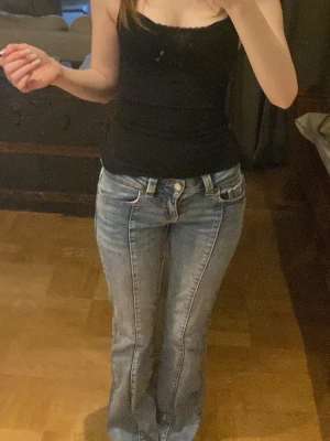 Ljusblå bootcut jeans med broderi - Säljer ett par ljusblå bootcut jeans med broderade detaljer på bakfickorna och fram benen. Jeansen har klassisk femficksmodell och låg midja. Passar mig i längden och jag är 160.