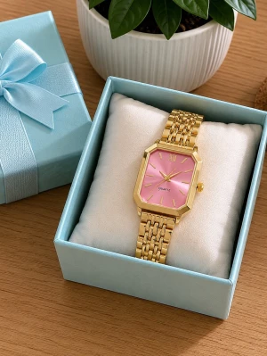 Guldig klocka med rosa urtavla - Stilren klocka med rektangulärt guldigt metallarmband och rosa urtavla. Klockan har romerska siffror vid tolvan och en elegant länkdesign. Perfekt accessoar för att lyfta din outfit.