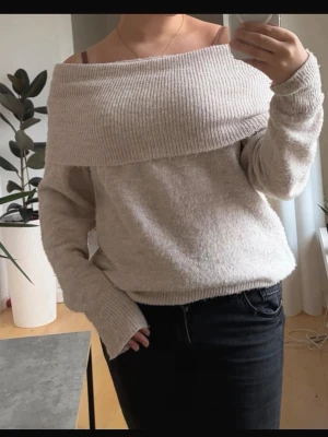 Beige off shoulder stickad tröja - Trendig beige stickad tröja med bred off shoulder-krage och långa ärmar. Mjuk och skön kvalitet, perfekt för lager på lager. Säljer pga att jag ej använder längre💕