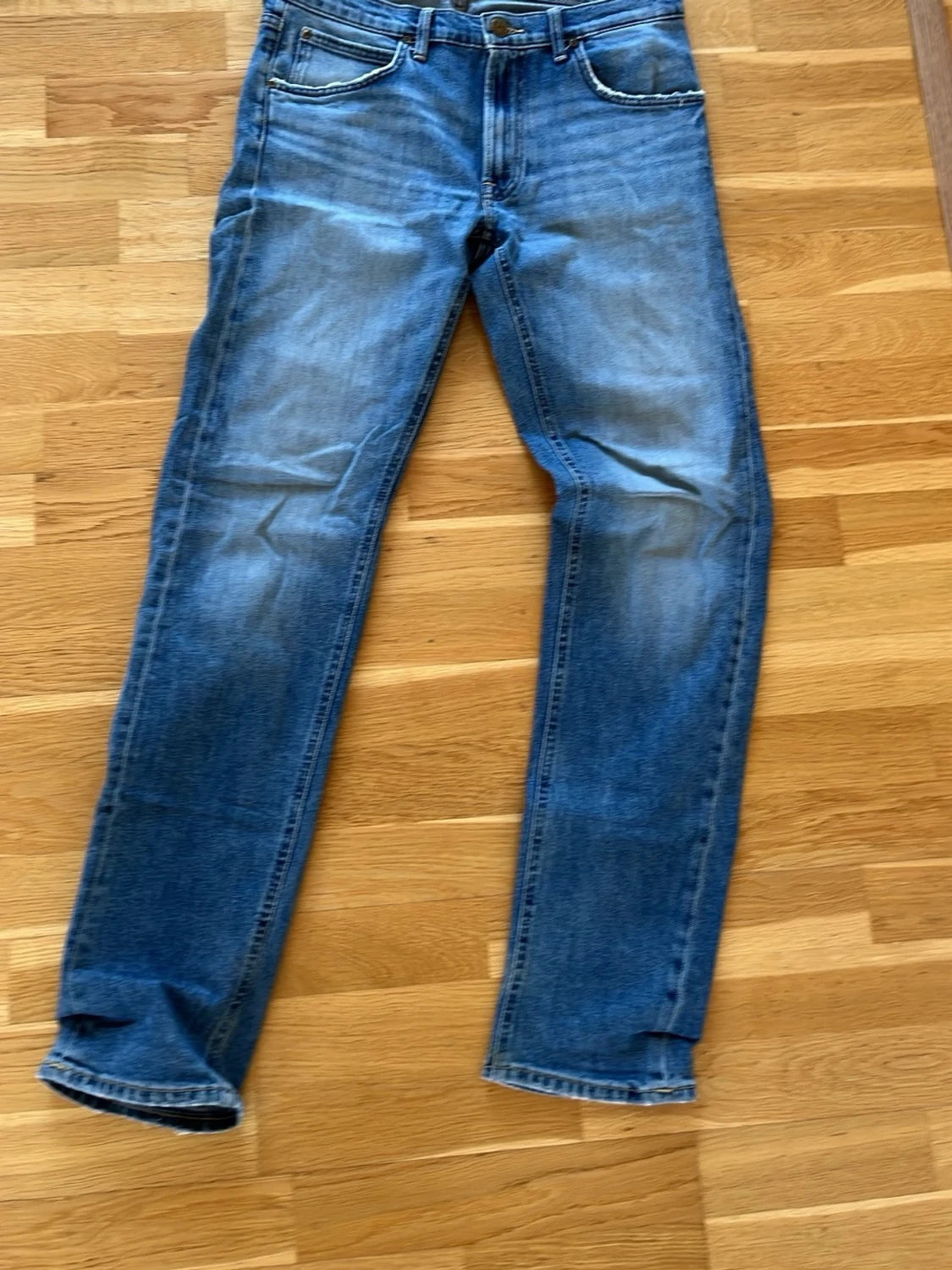 Blå raka jeans med slitningar
