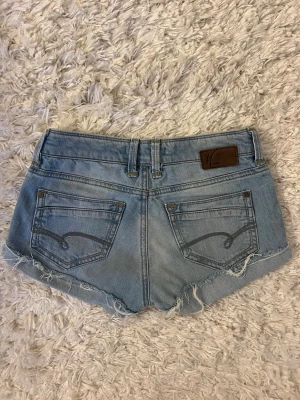Ljusblå jeansshorts med spetsdetaljer - Ljusblå jeansshorts från Mavi. Storlek 26/34, midjemåttet ca 34cm rakt över. Skriv för fler bilder. Hör av er vid några funderingar!