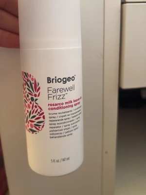 Briogeo Farewell Frizz conditioning spray - Briogeo Farewell Frizz Rosarco Milk leave-in conditioning spray, 147 ml. Vit flaska med färgglad dekor och svart text. Perfekt för att motverka frissigt hår och ge extra fukt och näring. Sprayformat för enkel applicering. Helt ny