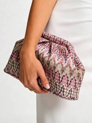 Mönstrad rosa clutch somrig HELT NY! - Säljer en unik clutch med ikoniskt zigzag-mönster i rosa, beige, brunt och svart. Väskan har en mjuk, puffig form och är tillverkad i textil med broderade detaljer. Perfekt för dig som gillar färg och mönster!