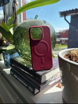 Vinrött mobilskal Holdit MagSafe (Iphone 16 pro) - Snyggt vinrött mobilskal från Holdit med MagSafe-kompatibilitet. Tillverkat i mjukt silikonmaterial som ger bra grepp och skydd. Skalets design är stilren med markerad MagSafe-ring och stor öppning för kameran. Perfekt för dig som vill ha både funktion och stil. (Nytt kostar 299)