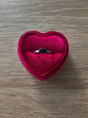 Silverfärgad ring med svart oval sten - ring i storlek 17,7mm, silverfärgad. 