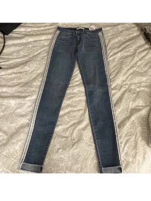 Levi's blå jeans med vita revärer - Säljer ett par blå skinny jeans från Levi's med vita revärer längs sidorna✨