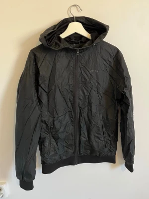 Svart vindjacka med huva - Snygg svart vindjacka med huva från Dirtcült, inget fel på den förutom att Dirtcült märket frampå har försvunnit 