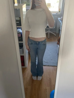 Vit tie-topp från Nelly  - Säljer en vit topp med snygg knytning i ryggen från Nelly. Toppen har en enkel och clean look som passar perfekt till vardagen men också till festligare tillfällen. Materialet känns lätt och luftigt, perfekt för varmare dagar.