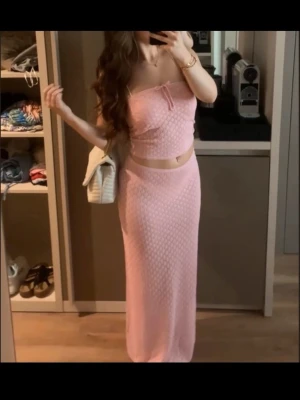 Rosa stickat set med kjol och topp - Säljer ett sött rosa stickat set med lång kjol och matchande tubtopp. Sista bilden är på kjolen längst upp