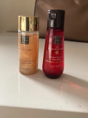 Rituals kroppsoljor duo - Två exklusiva kroppsoljor från Rituals: en skimrande body oil i guldton med guldfärgat lock och en röd natural dry oil med doft av indian rose & sweet almond. Smidiga flaskor, perfekta för att ge huden extra glow och näring.30ml/st