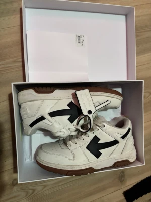 Off-White vita sneakers med svart pil - Säljer ett par Off-White sneakers i vitt läder med den ikoniska svarta pilen på sidan och brun sula. Skorna har en chunky design, vita skosnören och Off-White tag på ovansidan. Använda sparsamt. Köpta för 1.5 år sedan. 