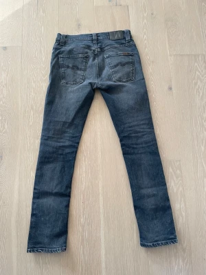Nudie Grim Tim svart/grå 30/32 nästan nyskick” - Säljer dessa feta Nudie jeansen i modellen Grim Tim W30 L32! Hör av dig vid frågor eller för fler bilder! Nypris ca 1800