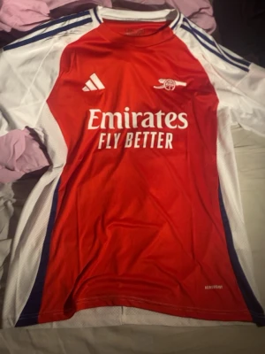 Arsenal T-shirt  - Hej jag säljer en arsenal T-shirt den är helt oanvänd då den inte passade skulle säga att den passar mer åt M hållet men kan även funka som L