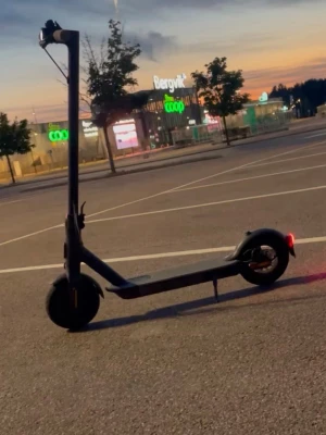 Svart elscooter med LED-bakljus - Säljer en svart elscooter med stilren design och LED-bakljus. Scootern har bred fotplatta, stora hjul och upprätt styre. Perfekt för att ta sig runt i stan på ett smidigt sätt. Laddas enkelt och har en modern look.