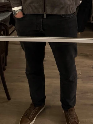 Acne Studios jeans herr - Säljer ett par mörkgråa jeans med klassisk femficksmodell och normal midja. Jeansen har en stilren look och passar perfekt till sneakers eller boots. Materialet är mjukt och stretchigt för extra komfort. Storlek 33/34 men skulle säga att de är lite mer som 32/32