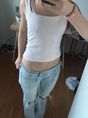 Rosa linnetopp - Säljer en enkel och fräsch rosa linnetopp med breda axelband och fyrkantig ringning. Toppen är ärmlös och har en tight passform som sitter snyggt på kroppen. Perfekt att styla med jeans eller kjol.