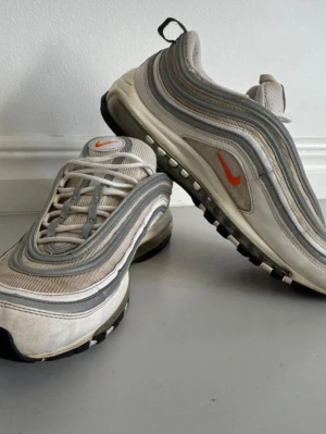 Nike Air Max 97 - Storlek 44.                                        Väldigt bra skick inga defekter.                   Vit och grå samt reflekteras i ljus.