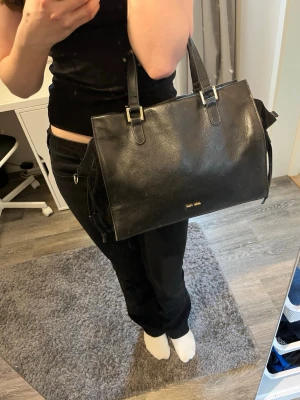 Baggy handväska med gulddetaljer - Snygg svart handväska från Anna Field i äkta läder med guldfärgade detaljer. Väskan har korta och långa löstagbara handtag och är endast använd ett fåtal gånger. Perfekt för dig som vill ha en stilren och klassisk accessoar till din outfit.