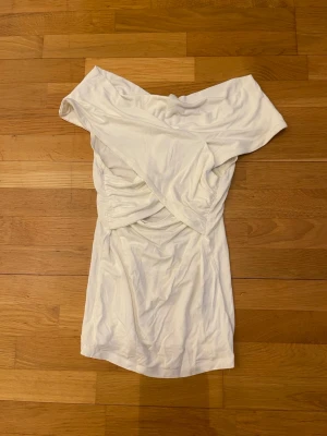 Vit offshoulder top - Snygg vit top från Gina tricot stl.xs. En figurnära passform och är tillverkad i ett mjukt material som känns bekvämt mot huden. Perfekt för dig som vill ha en stilren och trendig look. Toppen kan användas på båda hållen.