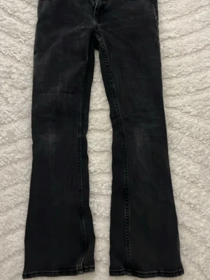 Svarta bootcut jeans från 157 - Säljer ett par svarta bootcut jeans från 157 med låg midja. Jeansen har klassisk femficksdesign och är tillverkade i ett slitstarkt denimtyg. Perfekta för dig som gillar en avslappnad men ändå trendig look.