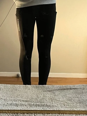 Ridbyxor  - Ett par svarta ridbyxor med två fickor på sidan har hel skoning. 