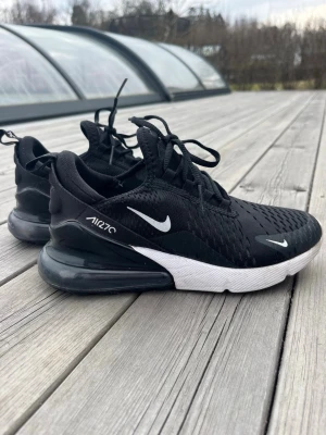Nike Air Max 270 svarta sneakers - Svarta Nike Air Max 270 sneakers med vit sula och tydlig Air Max-dämpning i hälen. Storlek 37,5