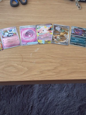 11 exclusive Pokémonkort - Säljer ett gäng Pokémonkort med olika motiv och färger, bland annat Meowth EX, Nosepass och flera holografiska kort. Perfekt för samlare eller dig som vill utöka din kortlek. Korten har färgglada illustrationer och varierande effekter.