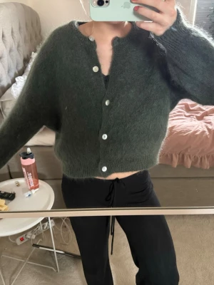 Mörkgrön fluffig kofta med knappar - Säljer en jätte fin kofta från Chelsea som är nästintill oanvänd. Materialet är känsligt (ylle/mohair), därför bör man tänka på hur man tvättar den så plagget inte krymper. Vet tyvärr inte vad det är för storlek, men passar bra på mig som vanligtvis har S. Nypris var ca 1000 kr.