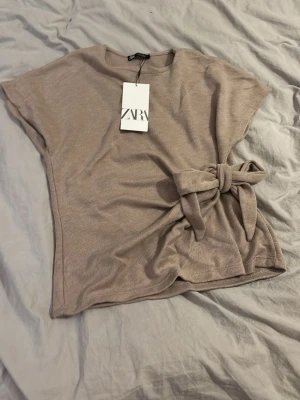 Beige topp med knyt från Zara -  beige topp från Zara med knytning. Den är inte använd.