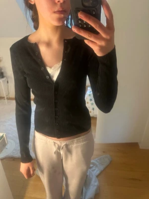 Svart ribbad cardigan med knappar - Tröja från lager 157. 