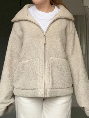 Beige teddyjacka med dragkedja - Mysig beige teddyjacka perfekt som vårjacka. Trendig teddyjacka från H&M. Står M men den passar mig jättebra som brukar ha S. 
