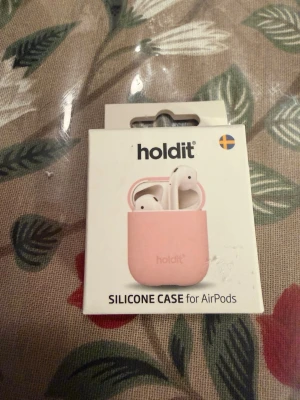 Rosa silikonfodral till AirPods Holdit - Snyggt rosa silikonfodral från Holdit som passar till AirPods. Fodralet är gjort i mjukt silikonmaterial och skyddar dina hörlurar mot repor och stötar. Perfekt för dig som vill ge dina AirPods en personlig touch och extra skydd.