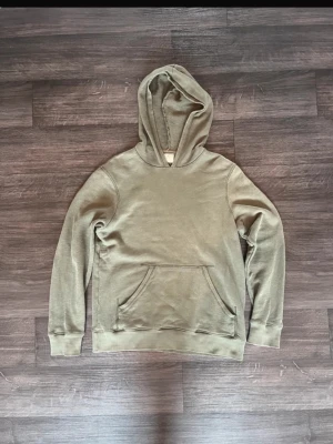 Nudie hoodie  - Säljer en stilren nudie hoodie med klassisk känguruficka framtill och ribbade muddar vid ärmslut och nederkant. Hoodien har en mjuk insida och en rymlig huva. Perfekt för en avslappnad och trendig look.