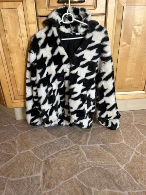 Svartvit teddyjacka - Säljer en fluffig teddyjacka i svart och vitt med stort stjärnmönster. Jackan är aldrig använd och storlek xxs!