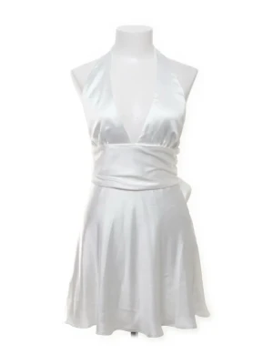 Vit omlottklänning i satin - Snygg vit kortklänning i glansigt satinmaterial med omlott och djup v-ringning. Klänningen har breda axelband, knyt i midjan och en fin rosett bak. Använd endast en gång, finns inte längre kvar på hemsidan!
