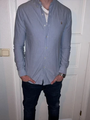 Ljusblå skjorta från Ralph Lauren - Ljusblå skjorta från Ralph Lauren i storlek S.  Fint skick till ett bra pris. Nypris: 1995kr. Mitt pris: 249kr. Vid frågor eller funderingar, tveka inte att höra av dig.