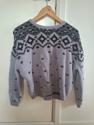 Stickad tröja med mönster - Säljer denhär söta stickade tröjan från H&M med svart mönster över axlarna. Den är i storlek 158/164, men skulle säga att den passar XS och S. Skriv till mig om du har några frågor!❤️